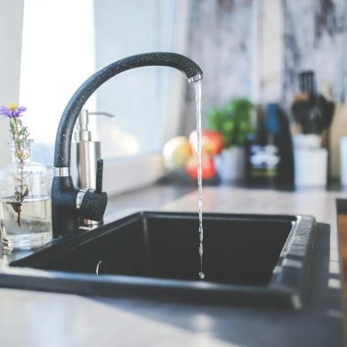 Kitchen faucet running with a clean sink after plumbing service in Sonoma County