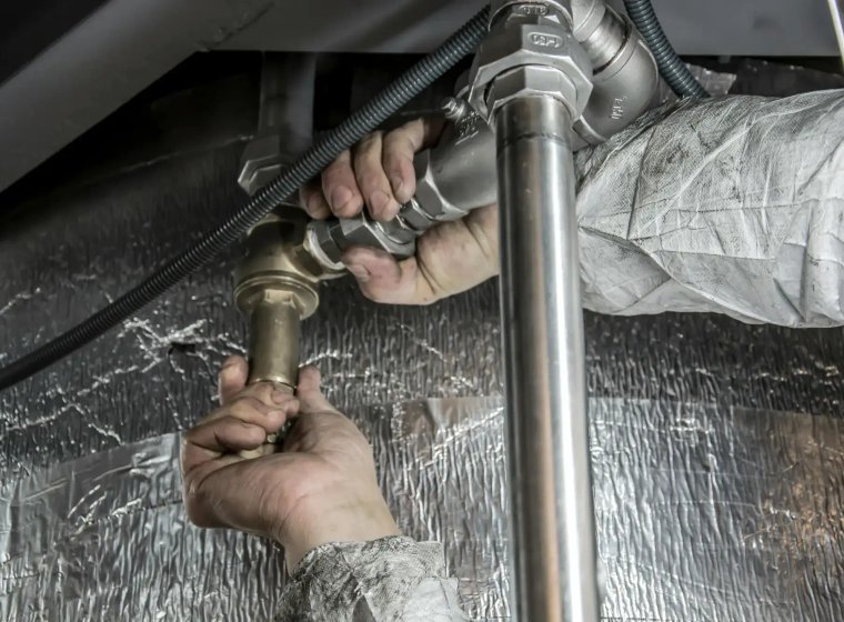 Hands-on pipe repair work under a sink