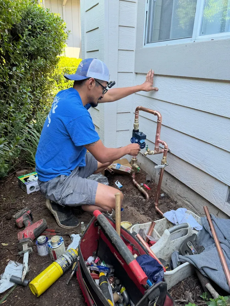 North Bay plumber working on exterior pipe connections