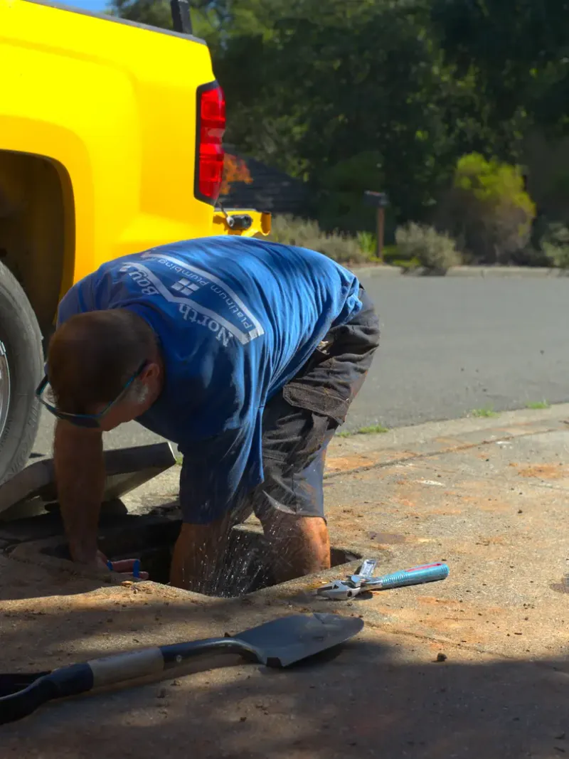 Plumbing technician working beside service equipment