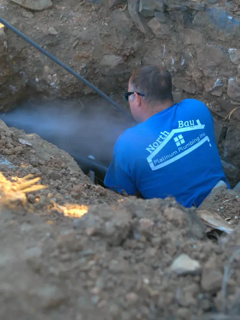 North Bay plumber working on piping below ground